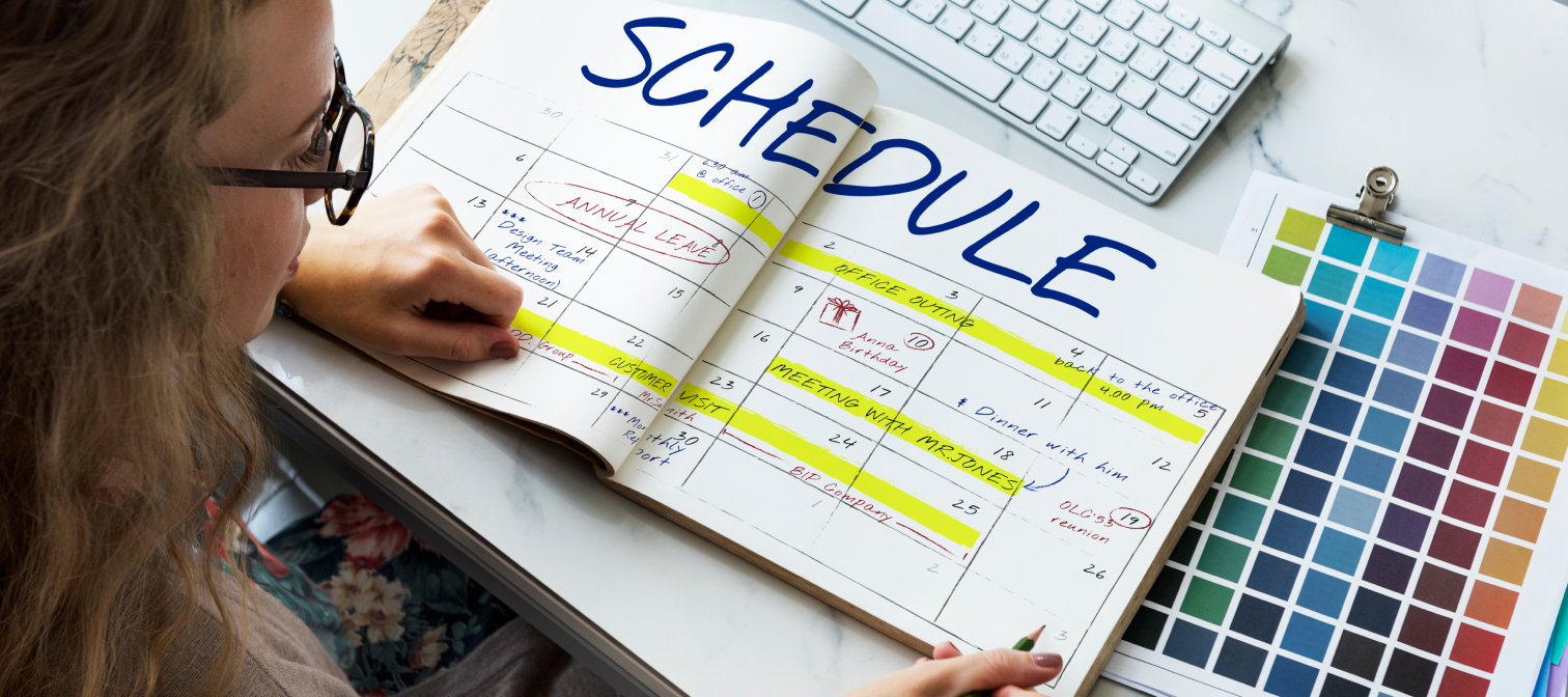 Girl with glasses reading a schedule notebook to stay organized as a Product Designer