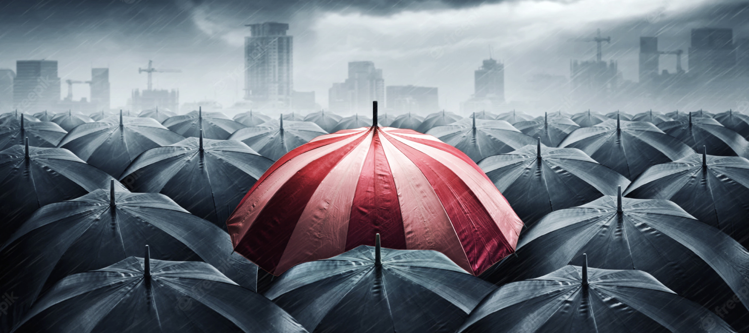 One red umbrella with black umbrellas in the background