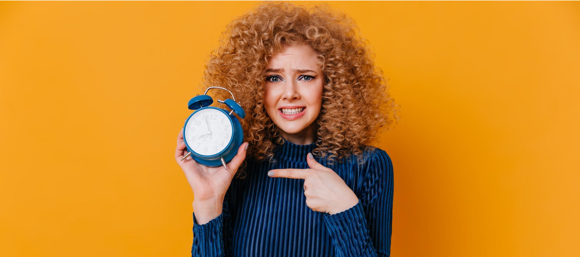 A girl is holding an alarm clock